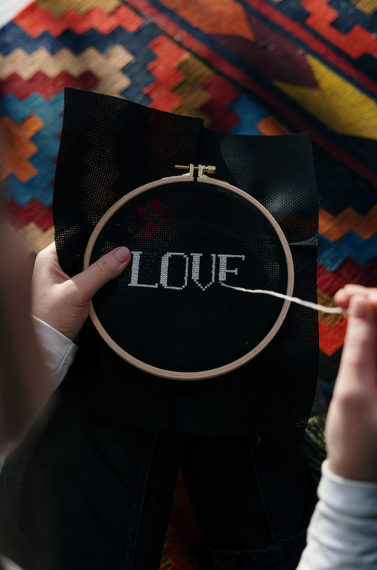 hånd broderi ordet love på sort stof