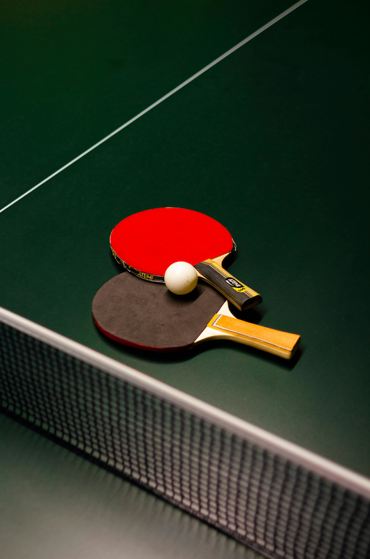 to bordtennisbat på et bordtennisbord og en hvid bold